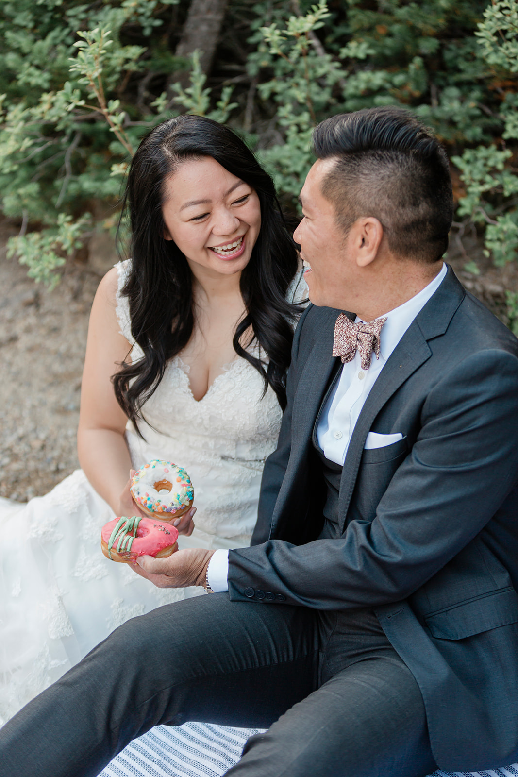 A couple shares donuts at their elopement picnic in Banff National Park. 