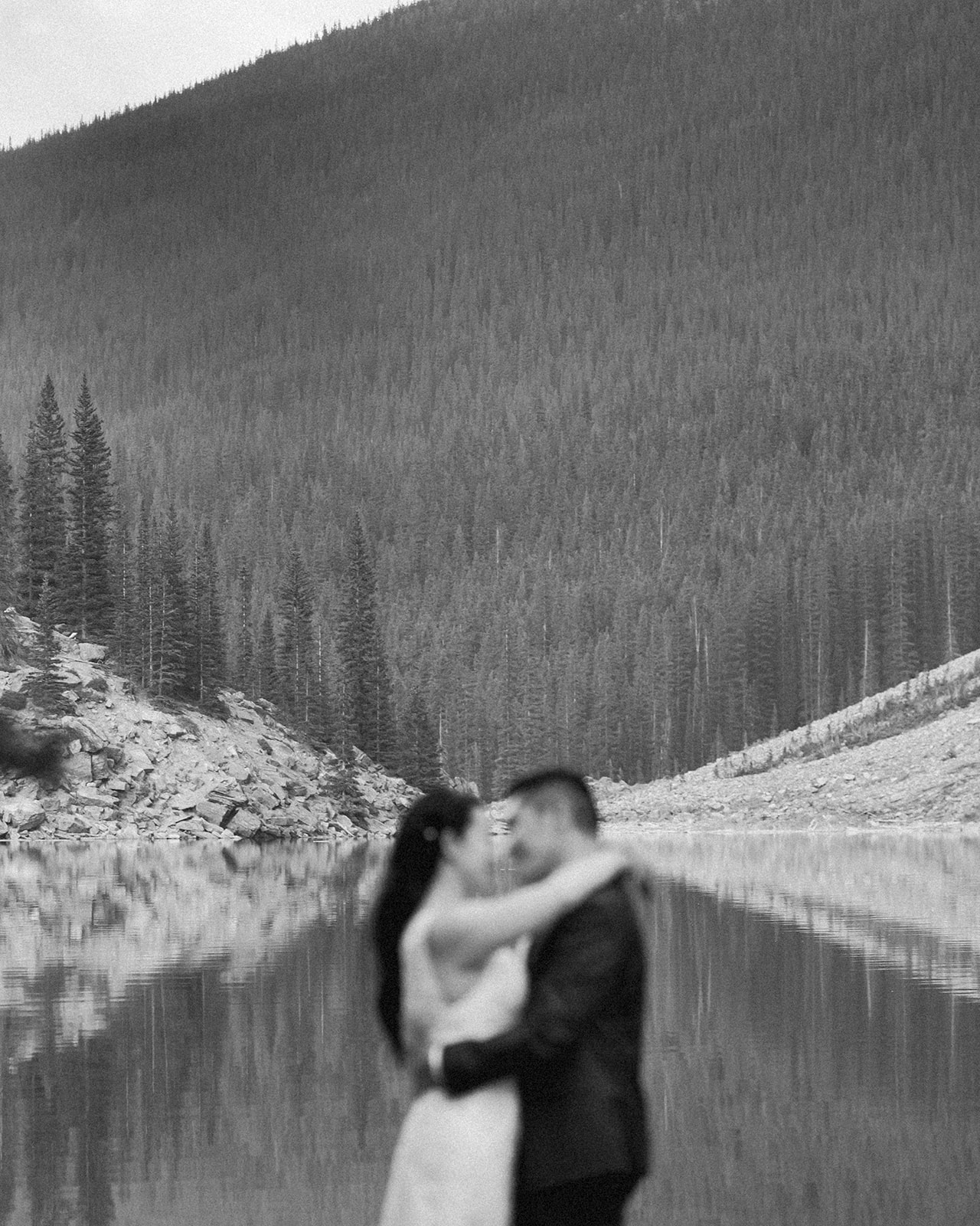 A bride and groom embrace during their Banff elopement near an alpine lake. 