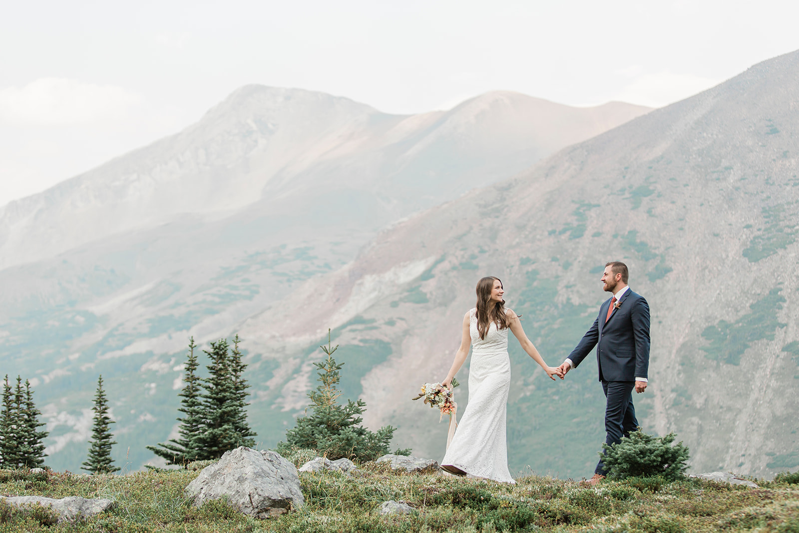 A newlywed couple walks along a ridge in Banff National Park during their Alberta wedding ceremony. 