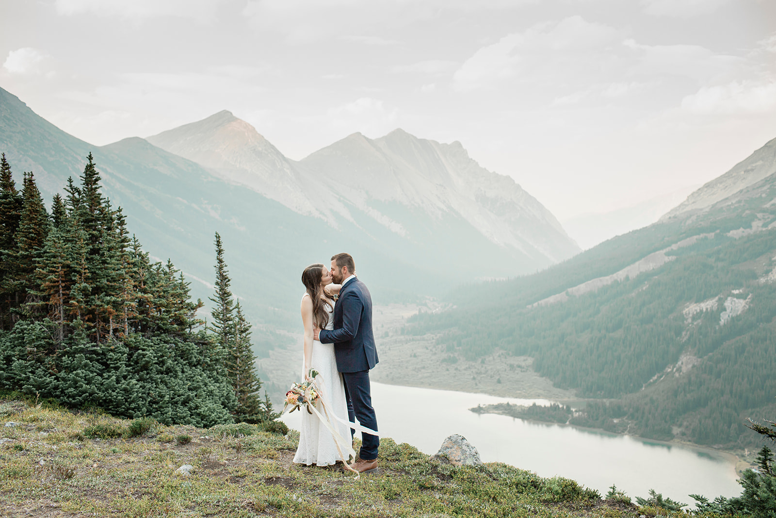 An Alberta wedding couple kisses on 
 an overlook during their Banff National Park ceremony. 