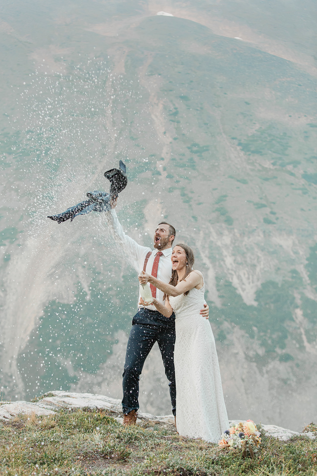 A newlywed couple celebrates their Banff National Park elopement with champagne. 