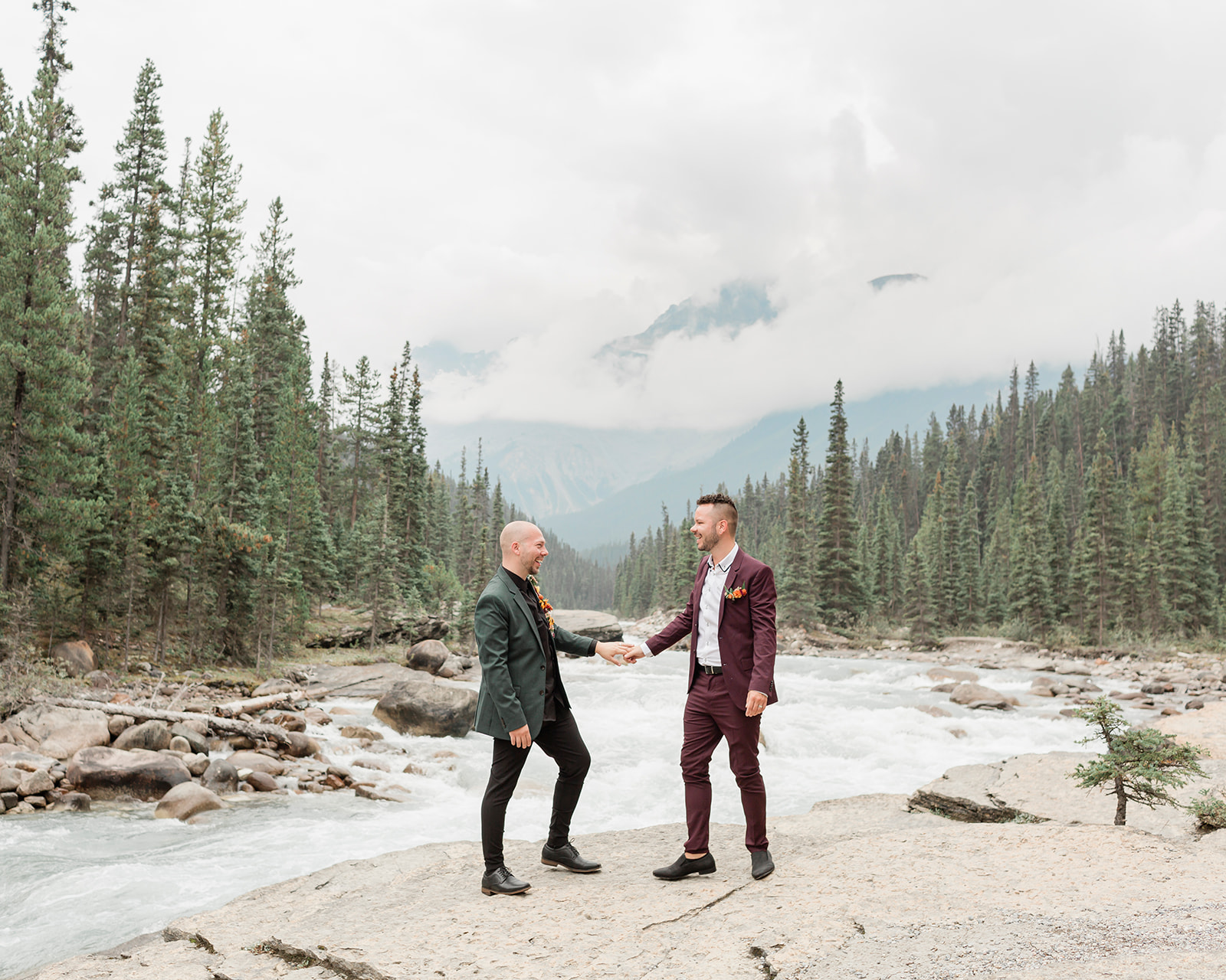 A Mistaya Canyon elopement couple holds hands and smiles at one another. 