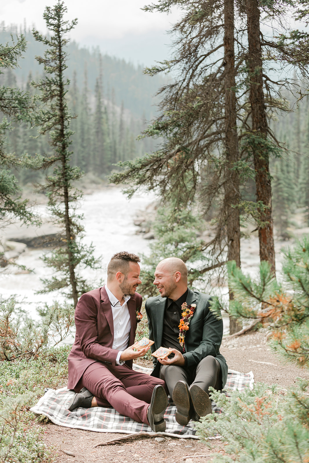 An adventure elopement couple shares pastries during a picnic at Mistaya Canyon. 