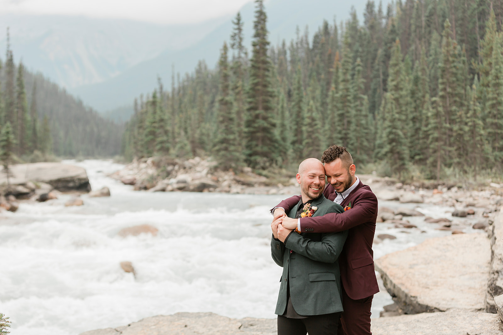 A Mistaya Canyon elopement couple embraces during an intimate outdoor wedding. 