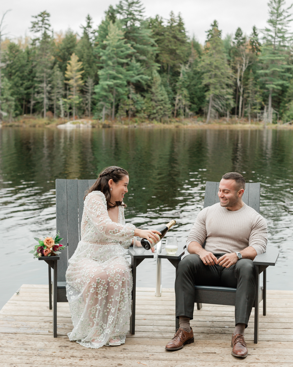 A couple that just got married in Haliburton Forest and are celebrating with a champagne pop