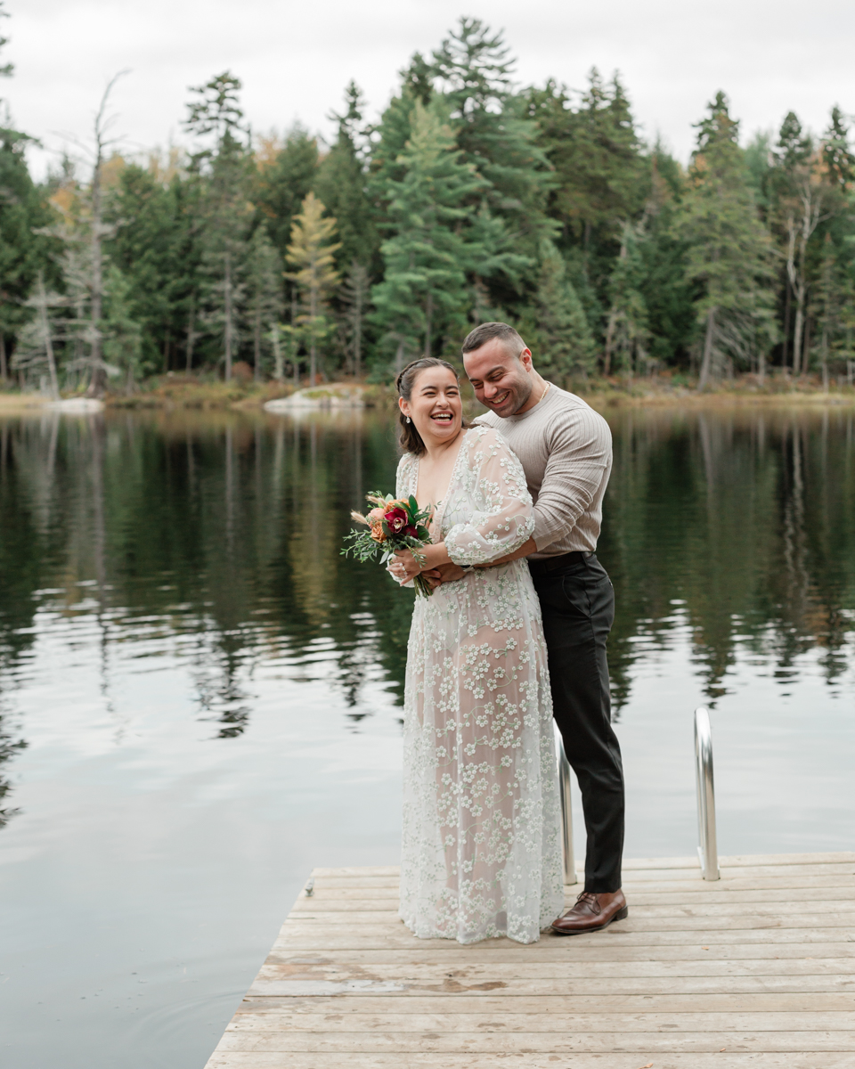 A couple laughing and embracing on a Muskoka doc post elopement 