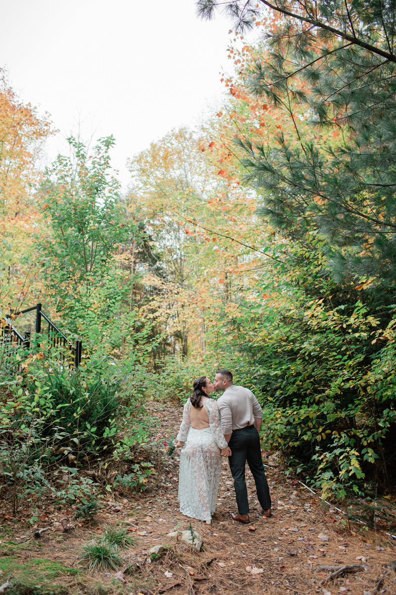 A couple kissing in front of their Muskoka off grid cabin after their wedding 