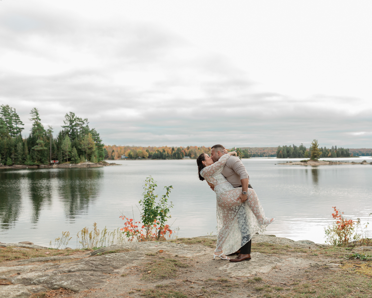 A couple kissing on a Muskoka lakefront after their wedding 