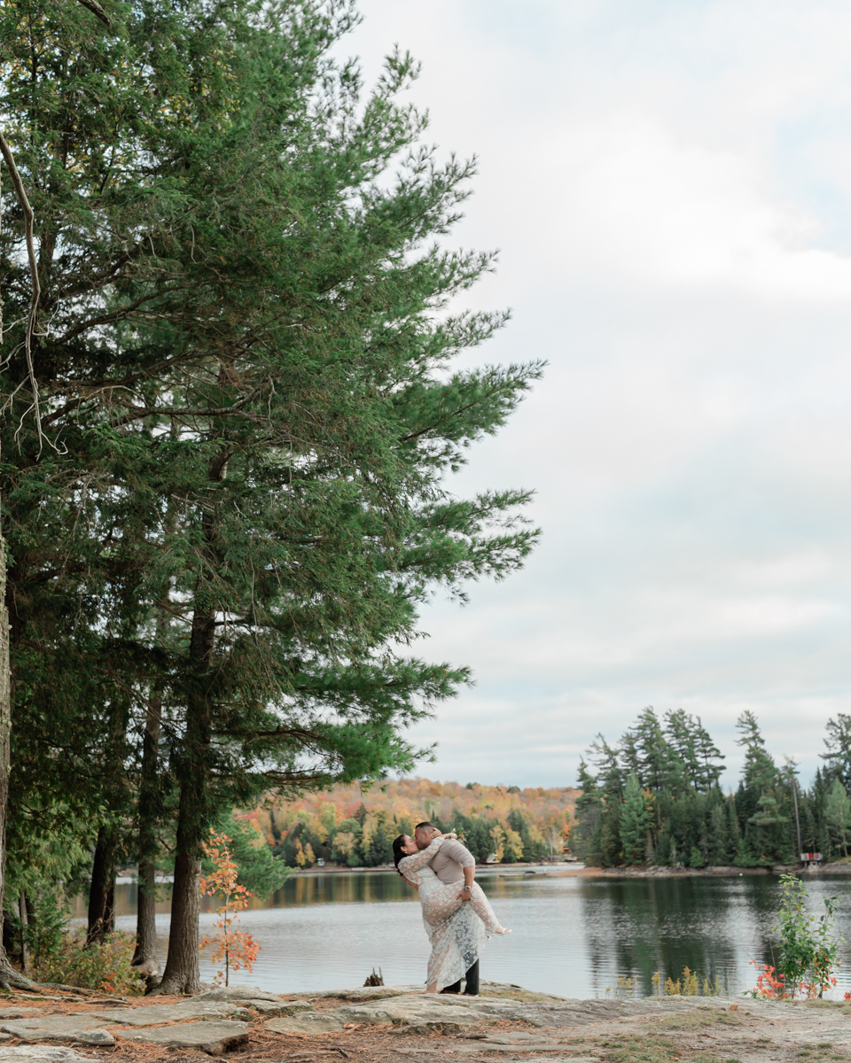 A couple kissing on a Muskoka lakefront after their wedding 