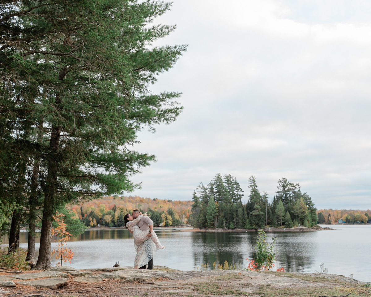 A couple dip kissing on a muskoka lake for their 