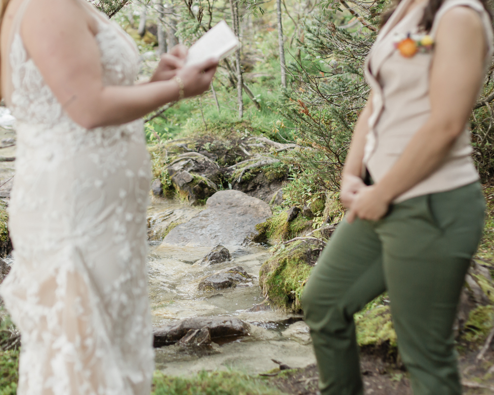 A couple exchanging vows and rings for their LGBTQ+ waterfall Banff elopement