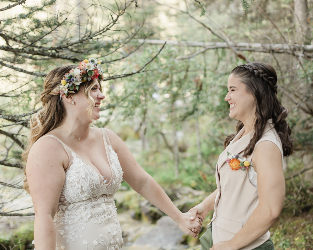 A couple exchanging vows and rings for their LGBTQ+ waterfall Banff elopement