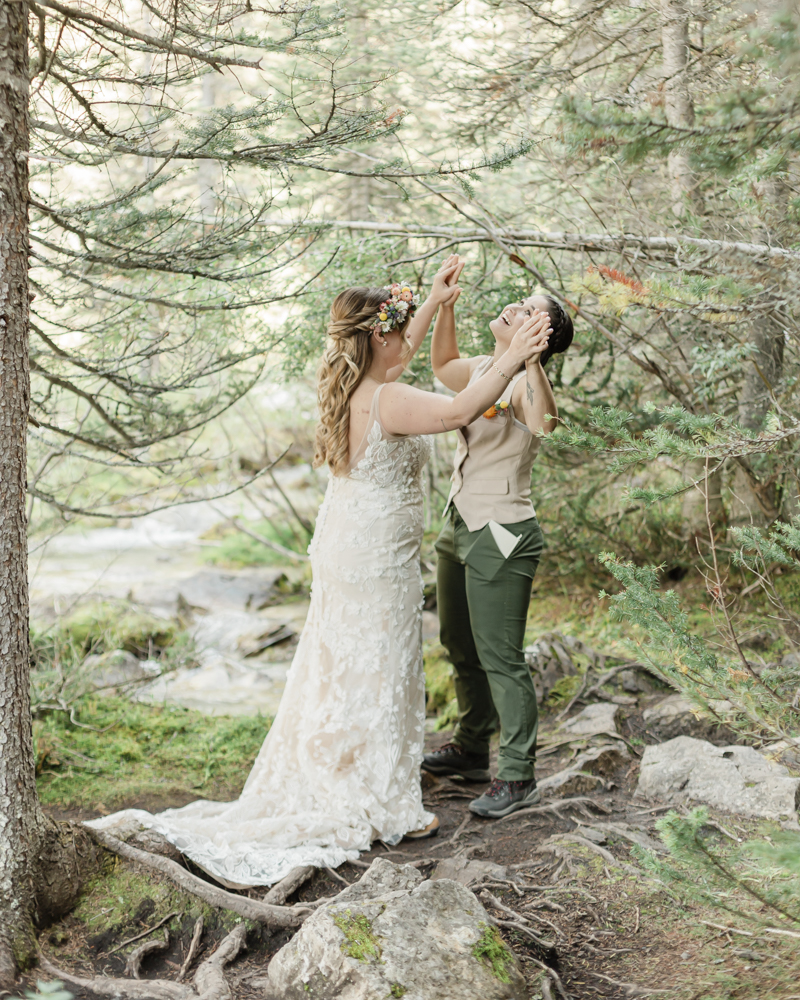 A couple exchanging vows and rings for their LGBTQ+ waterfall Banff elopement