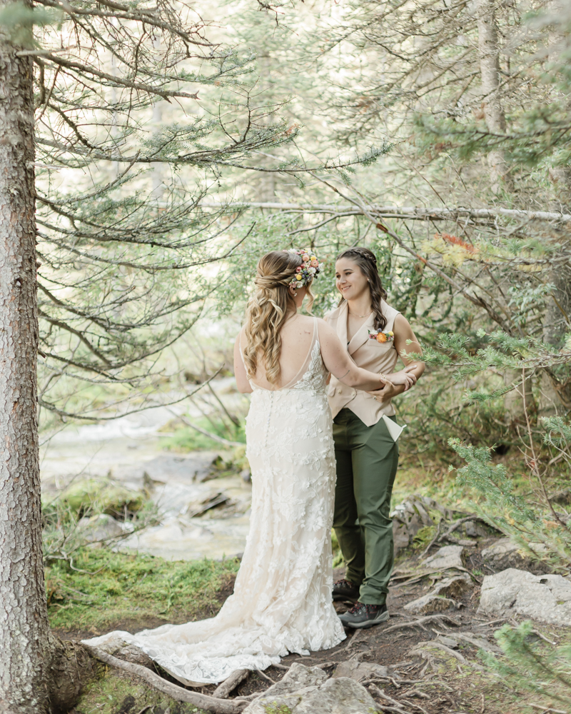 A couple exchanging vows and rings for their LGBTQ+ waterfall Banff elopement