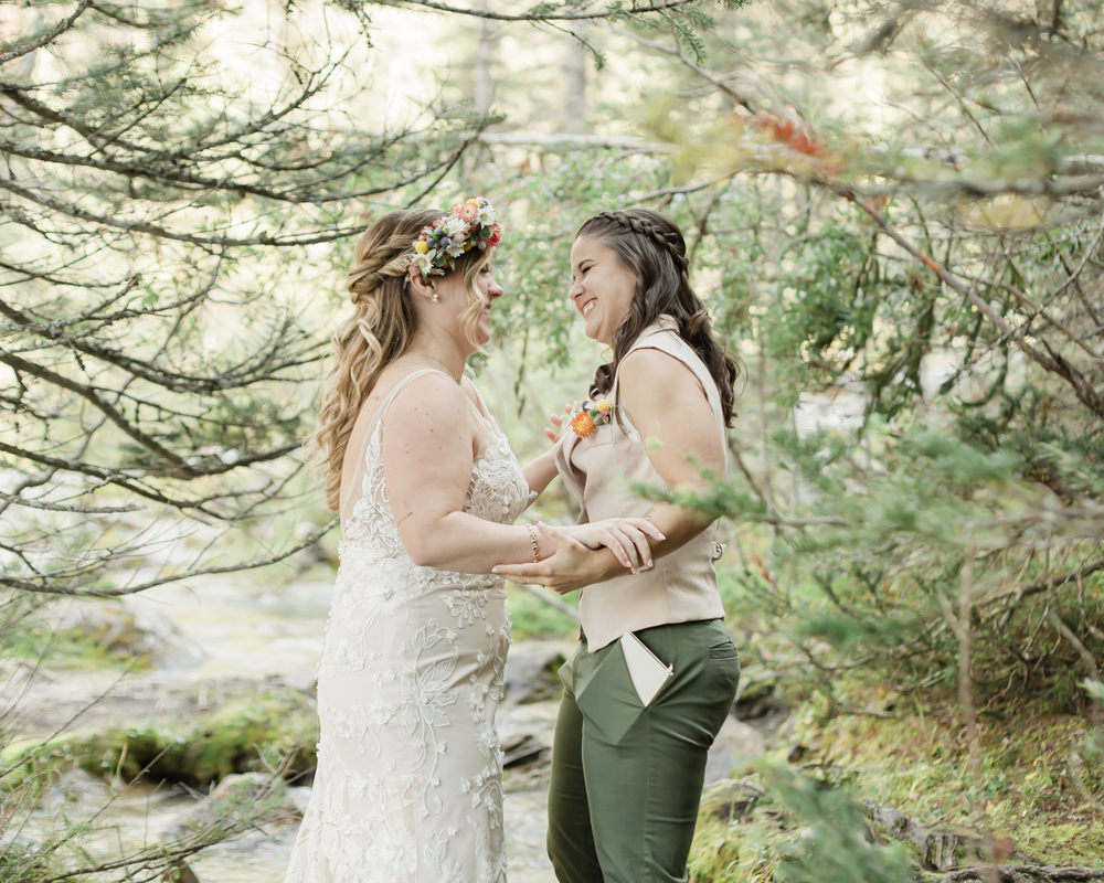 A couple exchanging vows and rings for their LGBTQ+ waterfall Banff elopement