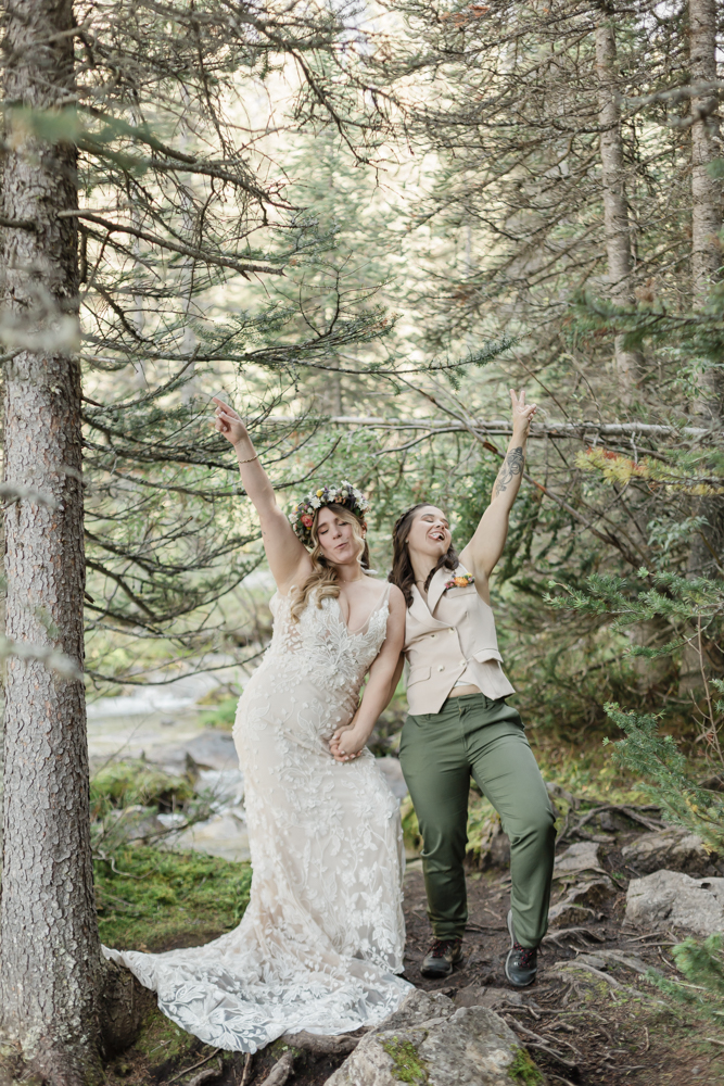 A couple exchanging vows and rings for their LGBTQ+ waterfall Banff elopement