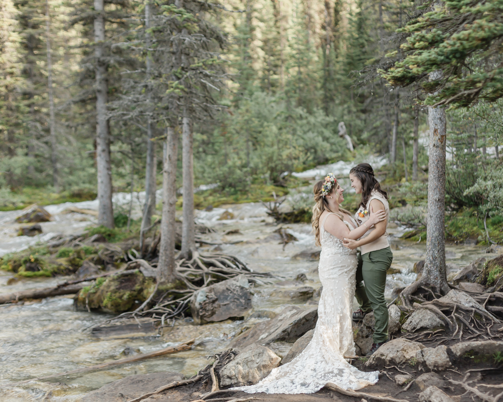 A couple laughing and embracing at Moraine Lake for their LGBTQ+ Banff elopement