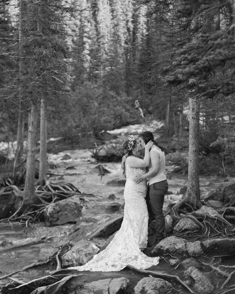 A couple laughing and embracing at Moraine Lake for their LGBTQ+ Banff elopement