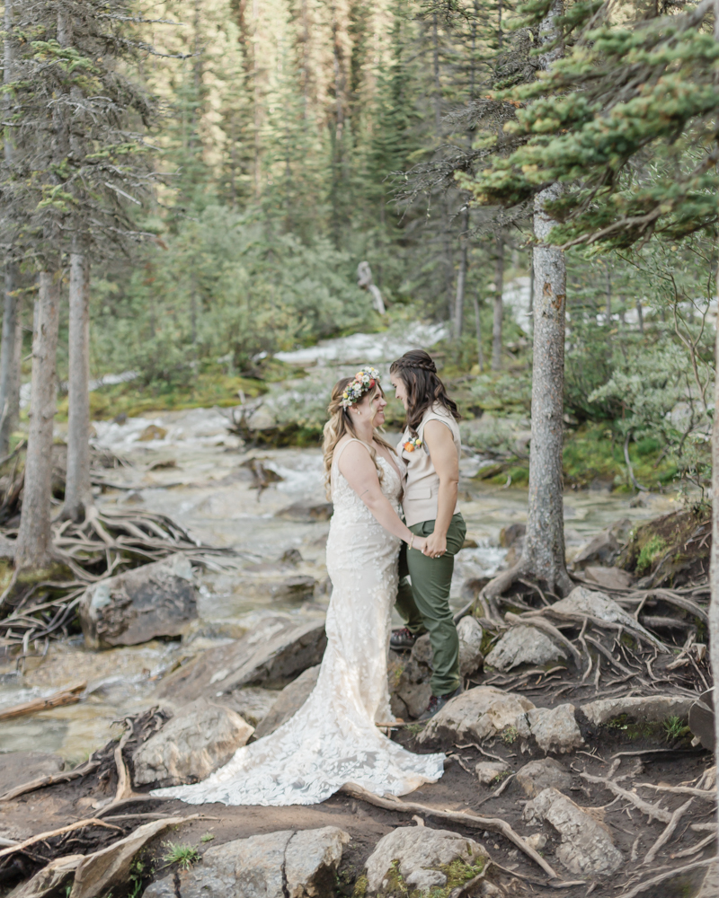 A couple laughing and embracing at Moraine Lake for their LGBTQ+ Banff elopement