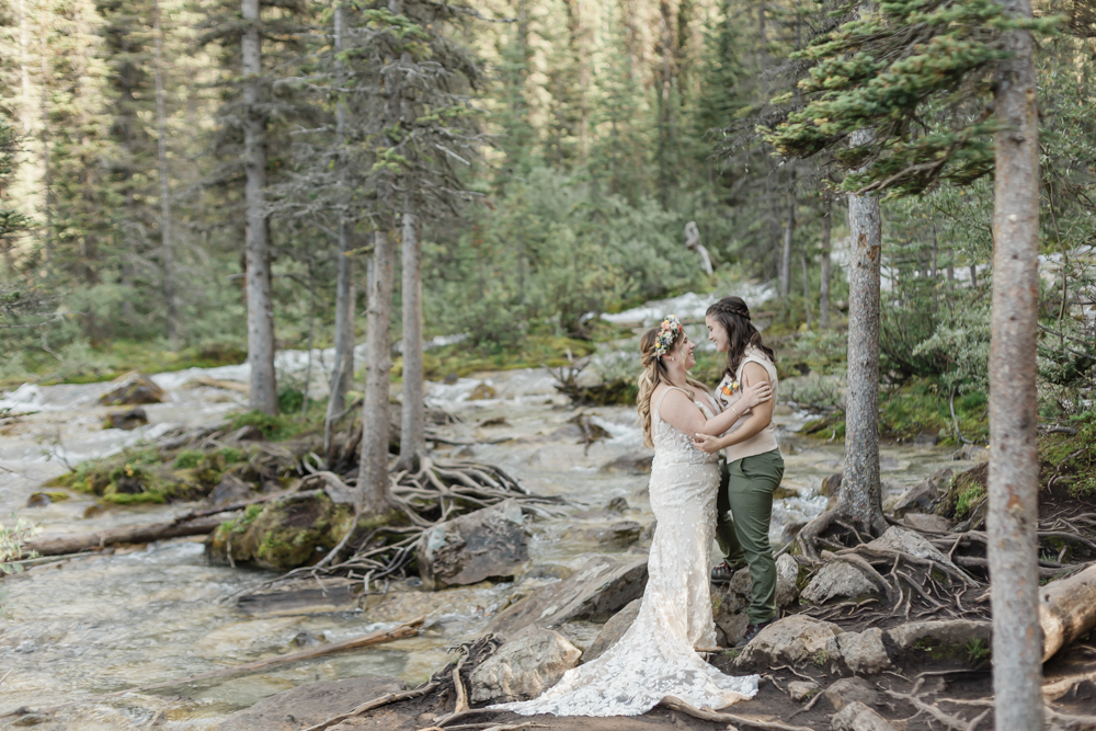 A couple laughing and embracing at Moraine Lake for their LGBTQ+ Banff elopement