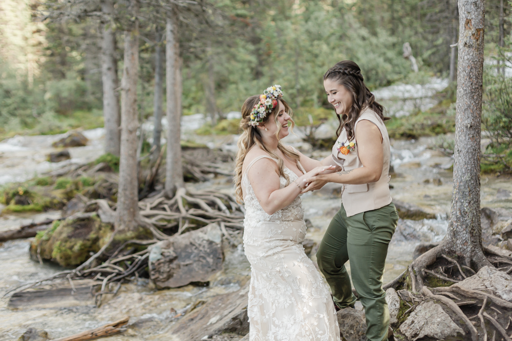 A couple laughing and embracing at Moraine Lake for their LGBTQ+ Banff elopement