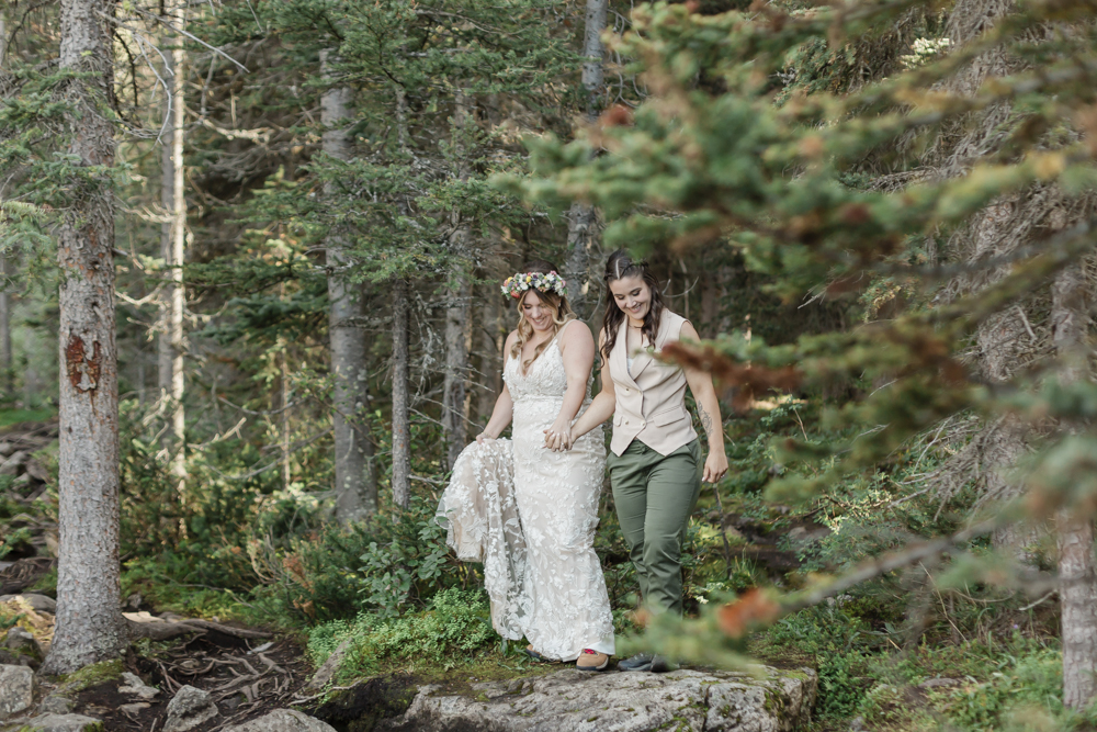 A couple laughing and embracing at Moraine Lake for their LGBTQ+ Banff elopement