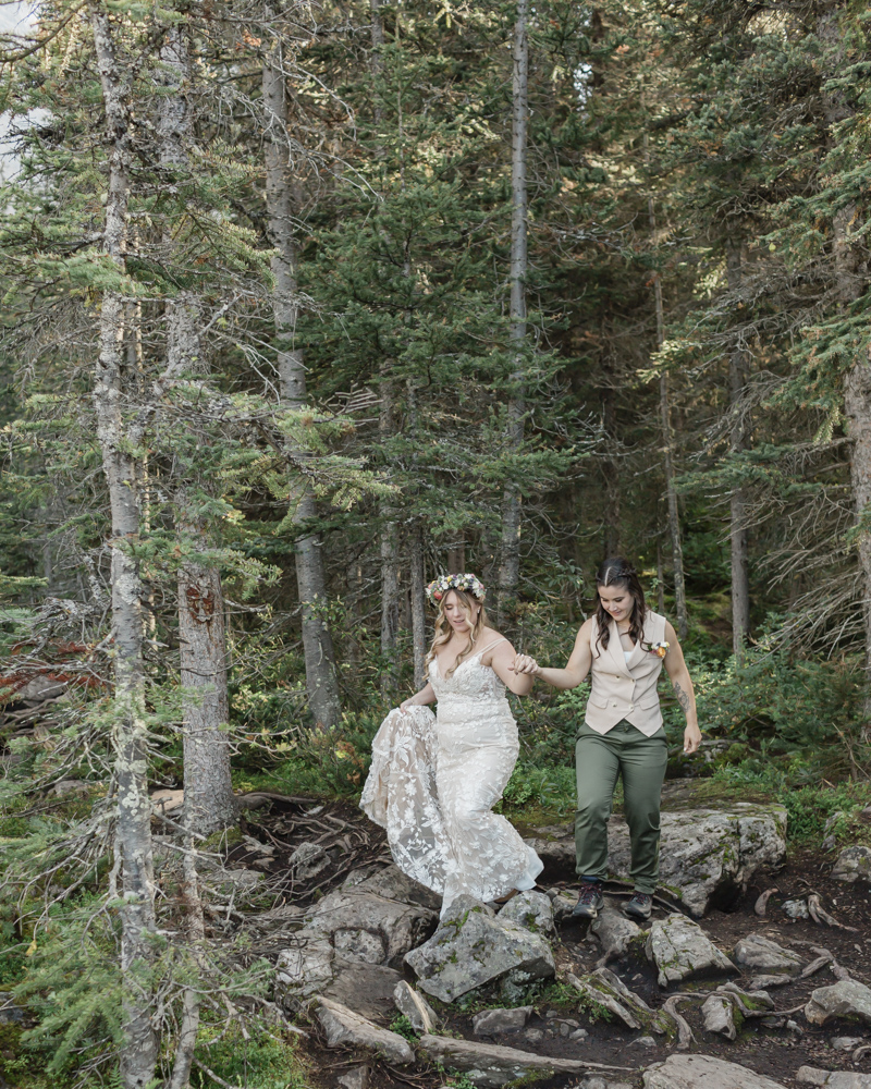 A couple laughing and embracing at Moraine Lake for their LGBTQ+ Banff elopement