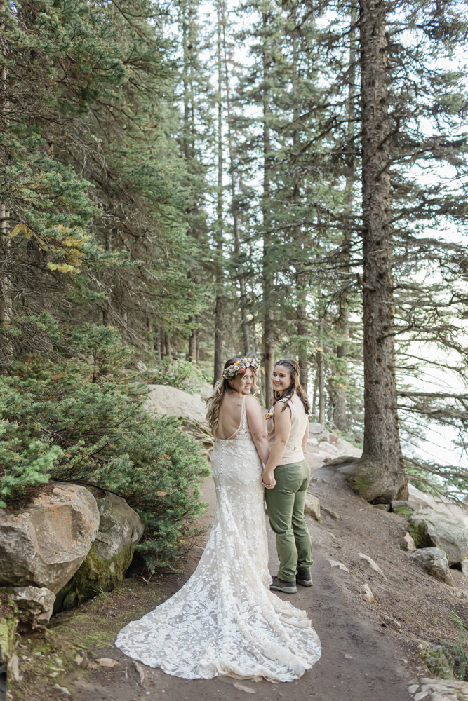 A couple laughing and embracing at Moraine Lake for their LGBTQ+ Banff elopement