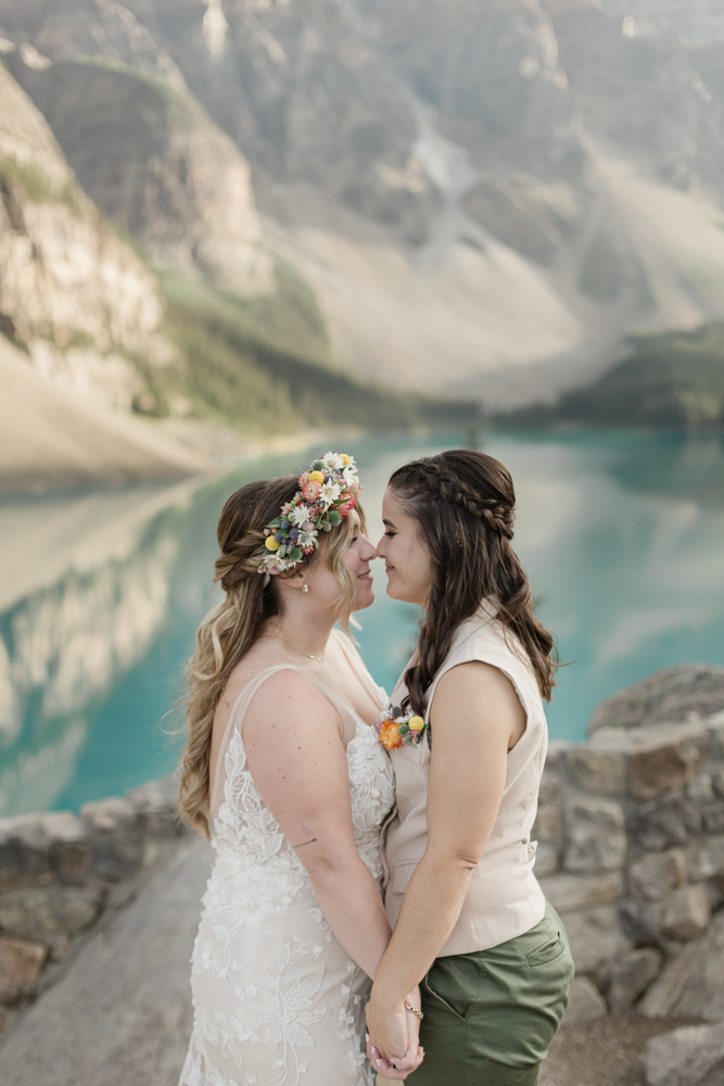 A couple kissing in front of Moraine Lake for their LGBTQ+ Banff elopement