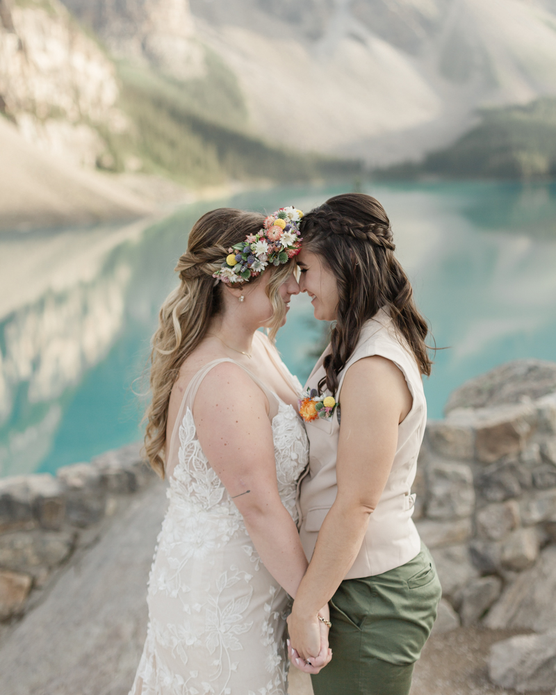 A couple kissing in front of Moraine Lake for their LGBTQ+ Banff elopement