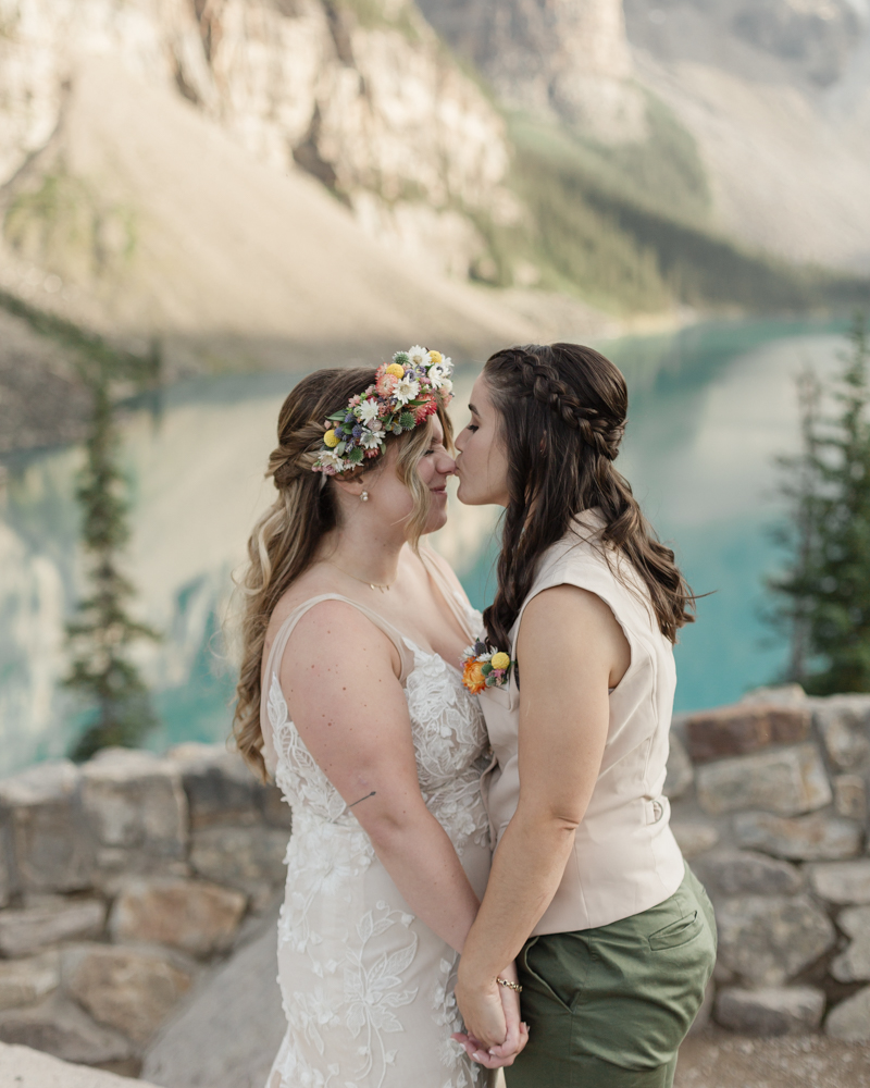 A couple kissing in front of Moraine Lake for their LGBTQ+ Banff elopement