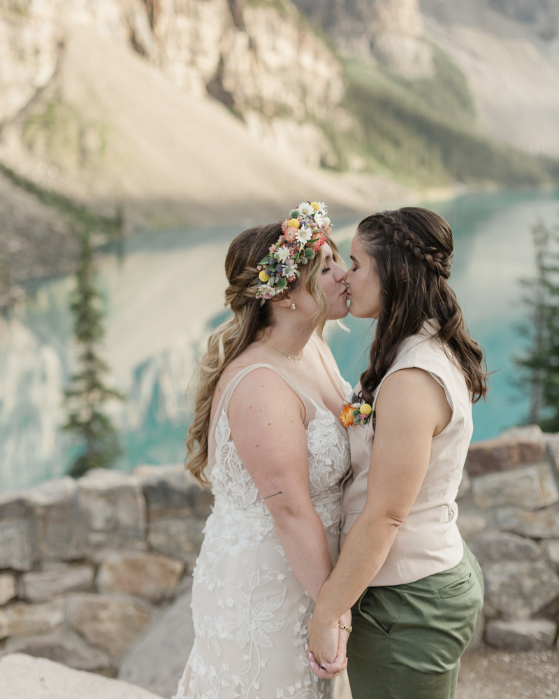 A couple kissing in front of Moraine Lake for their LGBTQ+ Banff elopement