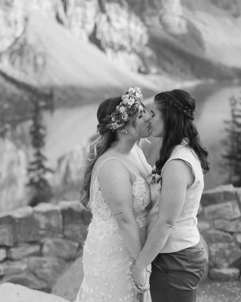 A couple kissing in front of Moraine Lake for their LGBTQ+ Banff elopement