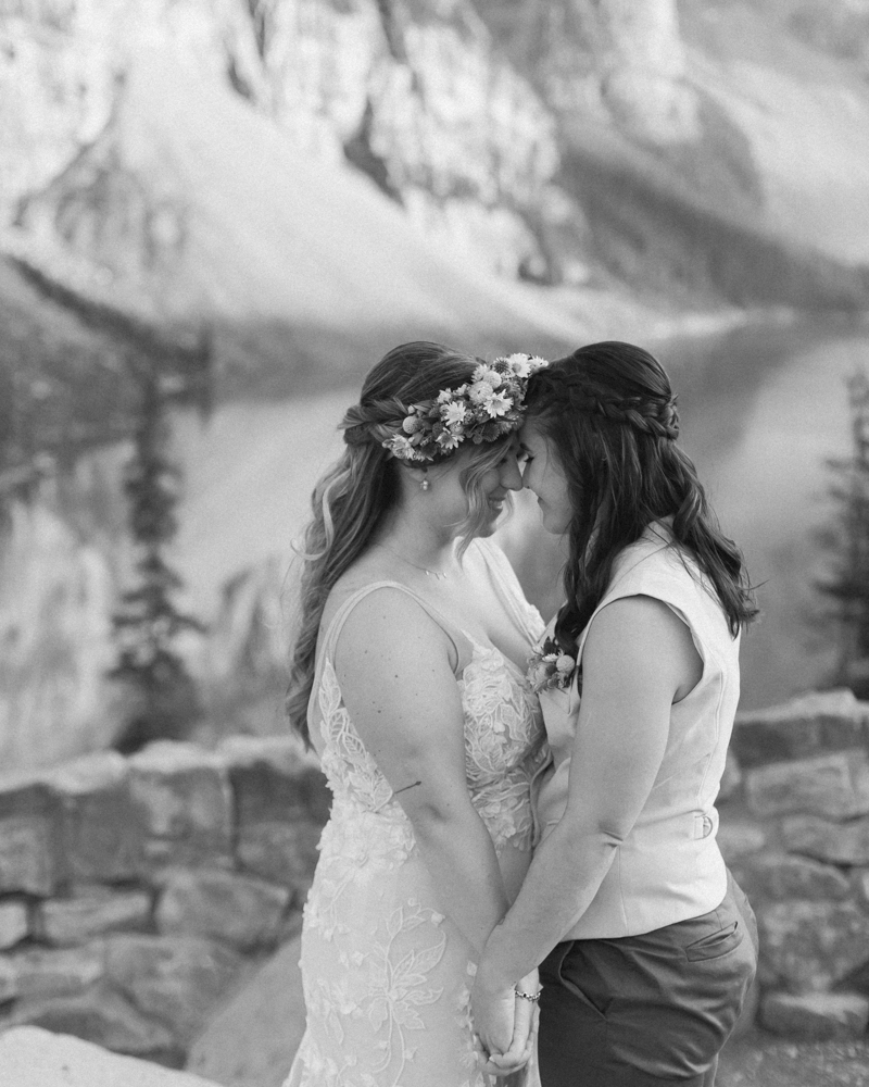 A couple kissing in front of Moraine Lake for their LGBTQ+ Banff elopement