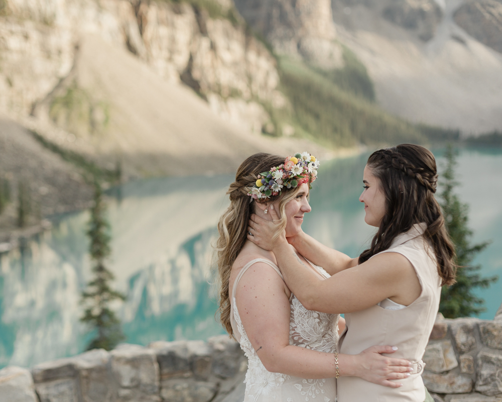 A couple kissing in front of Moraine Lake for their LGBTQ+ Banff elopement