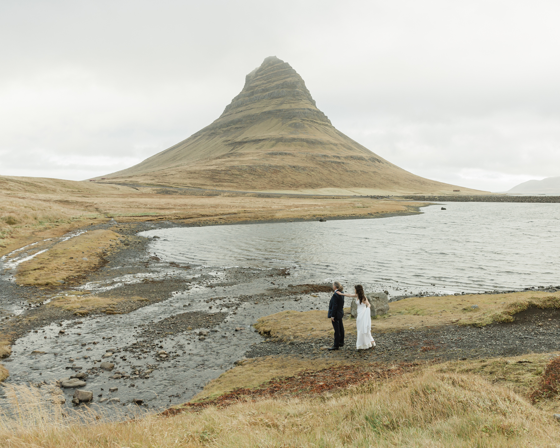 Kristen and Adam having their first look while facing Kirkjufell mountain in Iceland