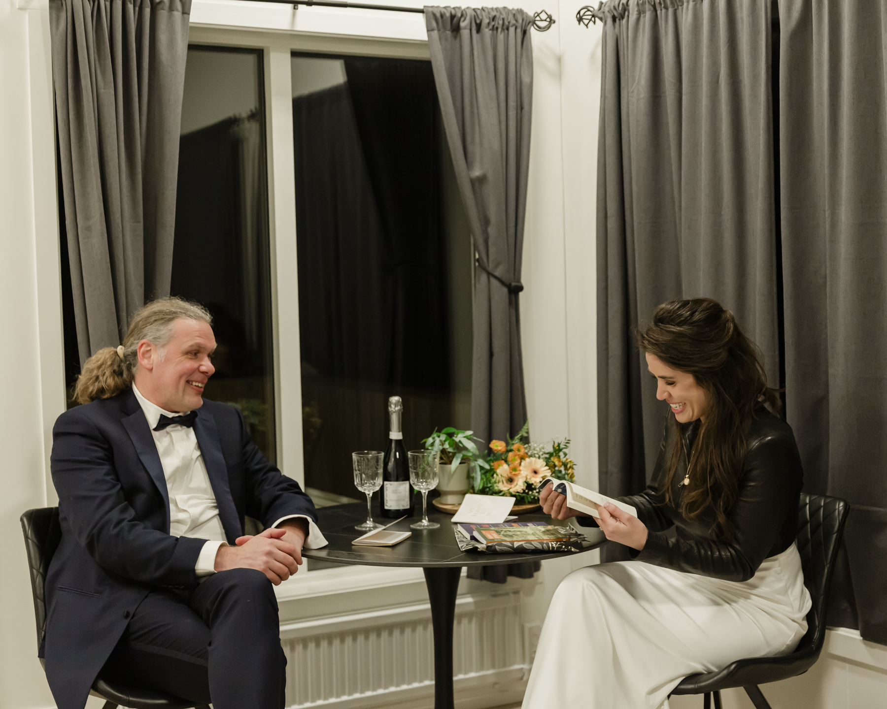 A couple exchanging gifts and celebrating with champagne at their airbnb after their Iceland wedding near Kirkjufell