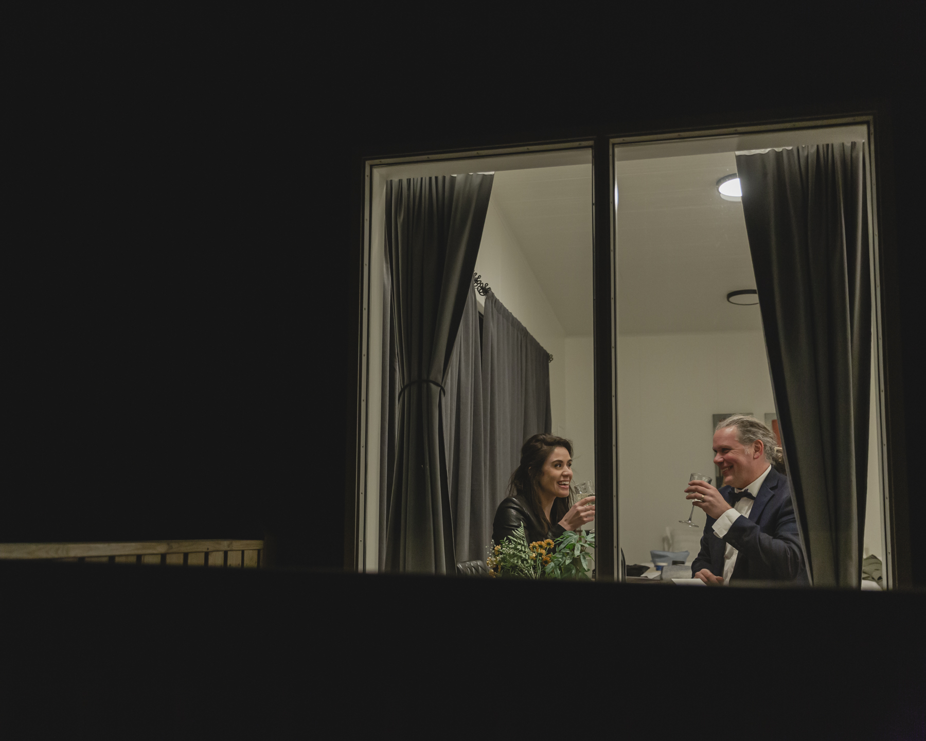 A couple exchanging gifts and celebrating with champagne at their airbnb after their Iceland wedding near Kirkjufell