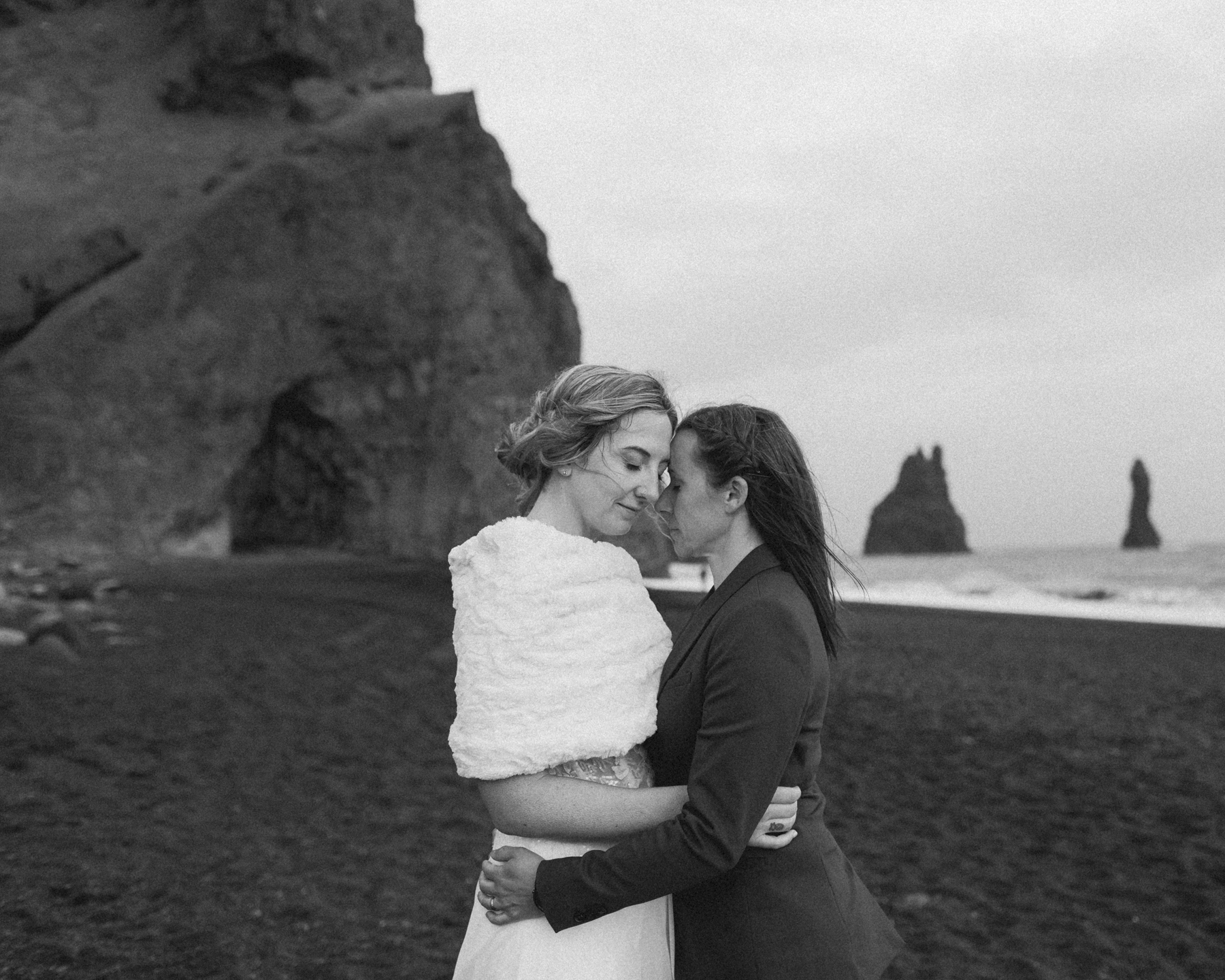 A couple embracing with their eyes closed after their elopement near Black Sand Beach