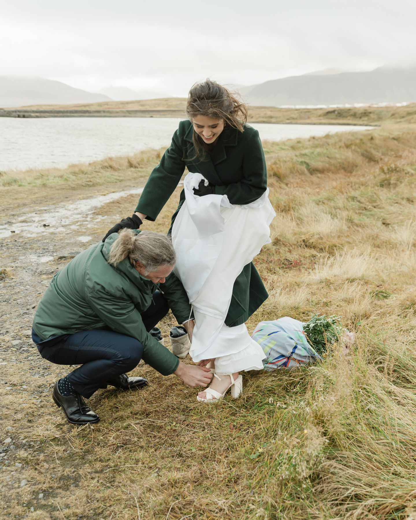 Adam helping Kristen put on her shoes at Kirkjufell mountain