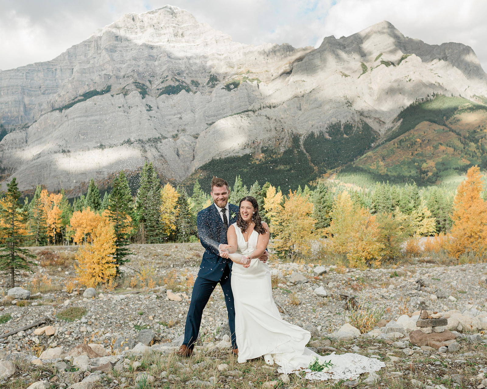 Couple celebrating a champagne pop in Kananaskis Country during their banff elopement