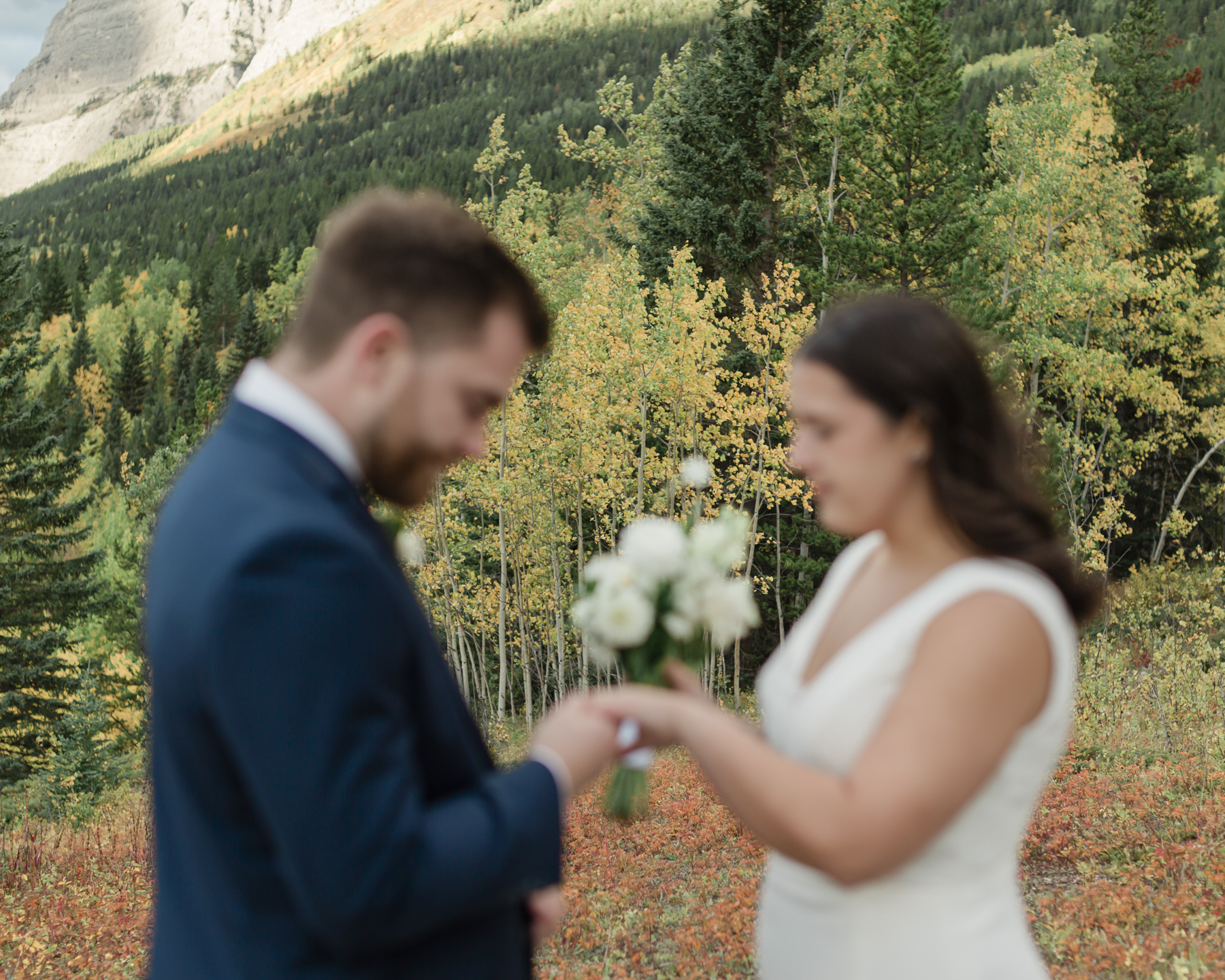 A couple exchanging vows and rings during their Kananaskis Country ceremony