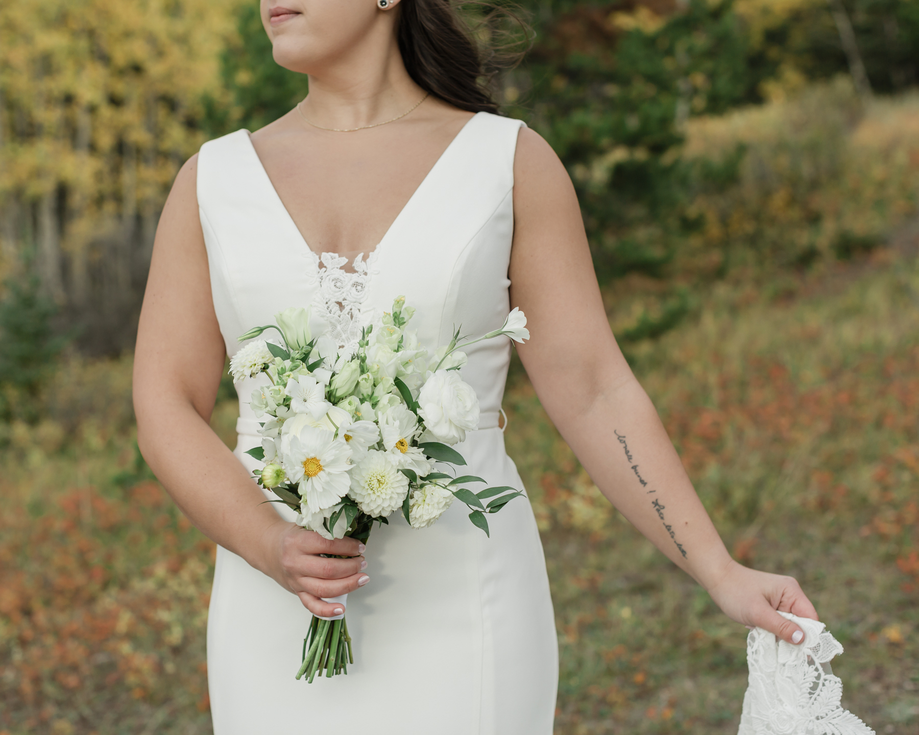 A couple looking at the camera and smiling during their Kananaskis Country ceremony