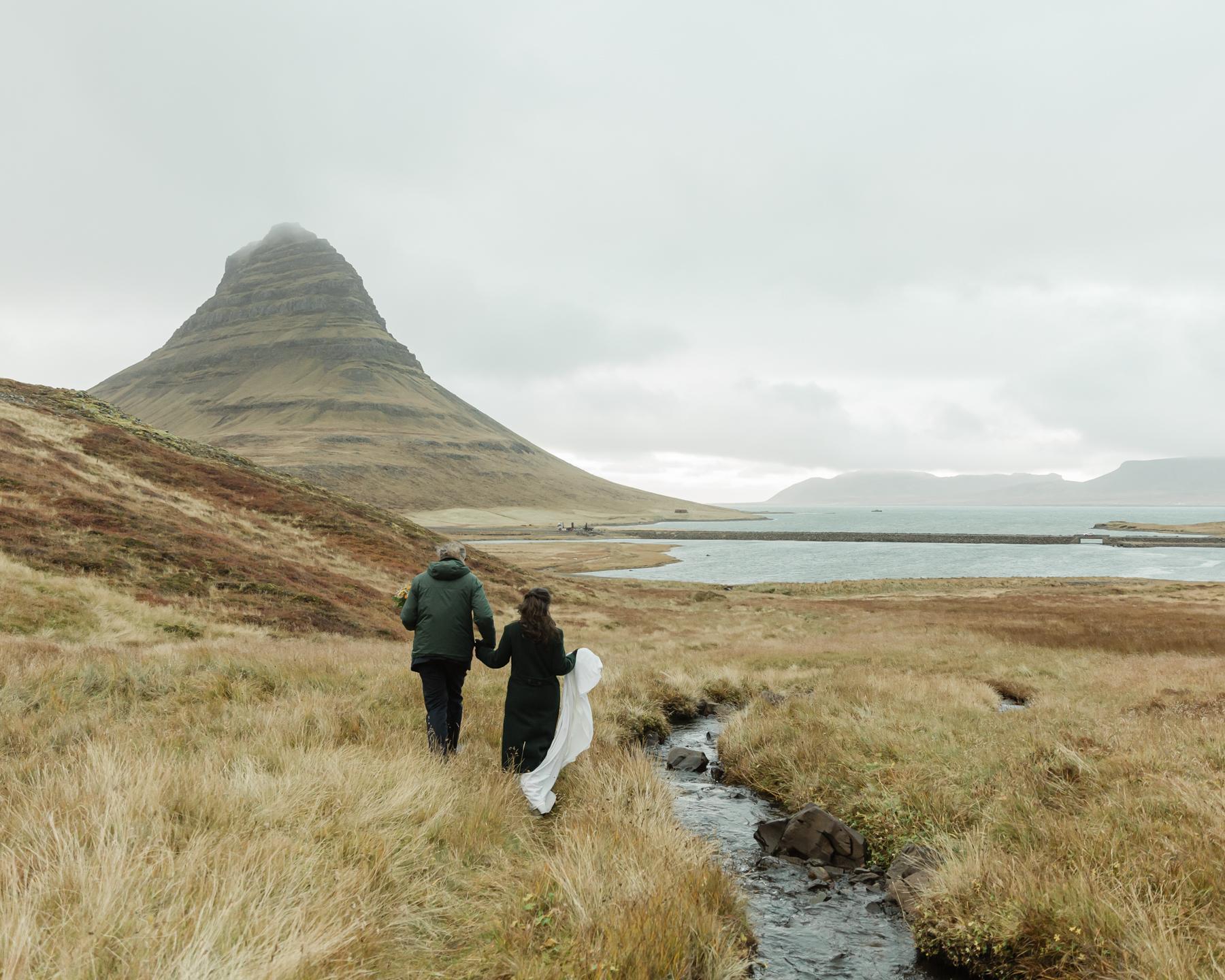 A couple walking towards Kirkjufell in Iceland