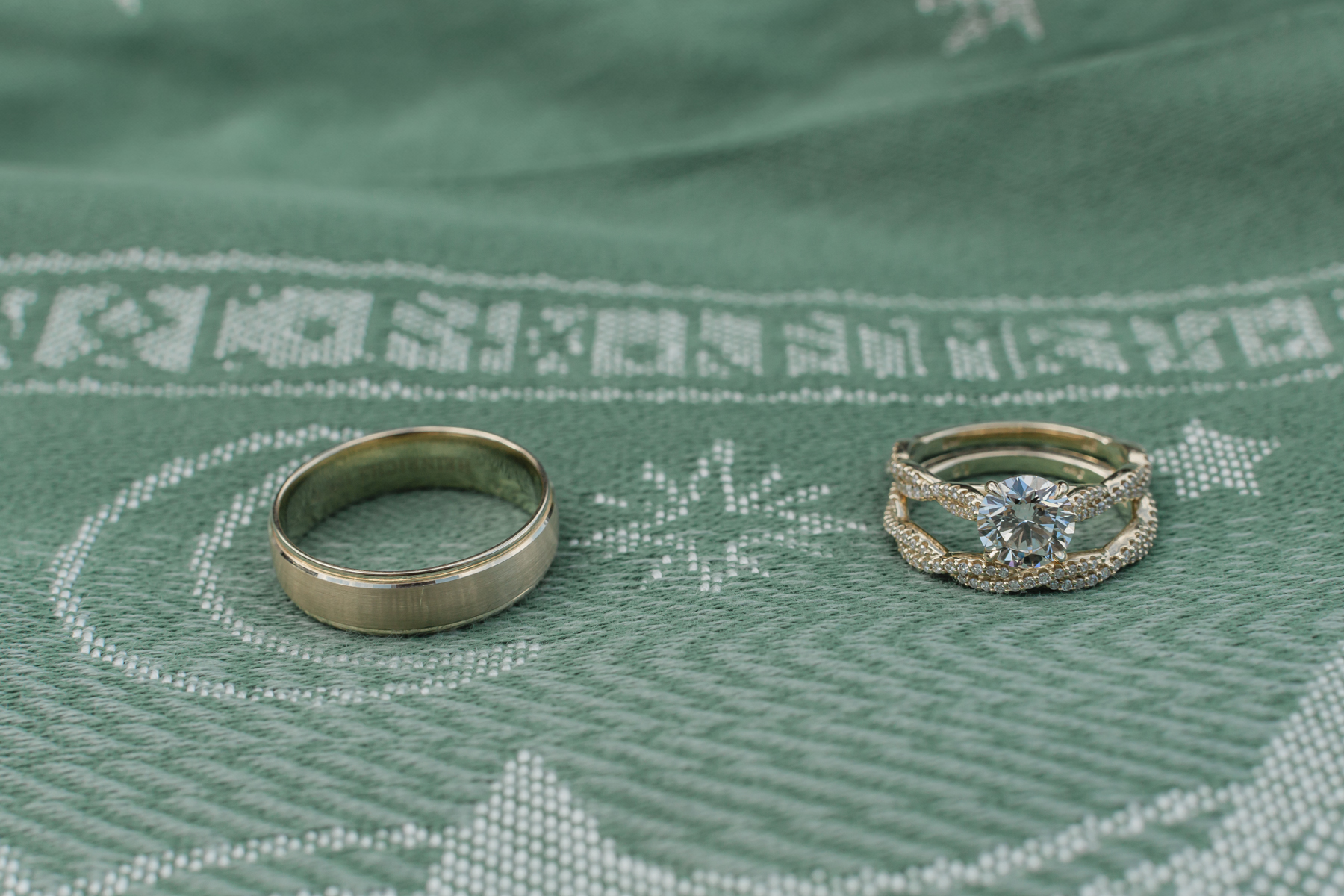 A couple's wedding rings on a mountain scape scarf with lord of the rings runes on it