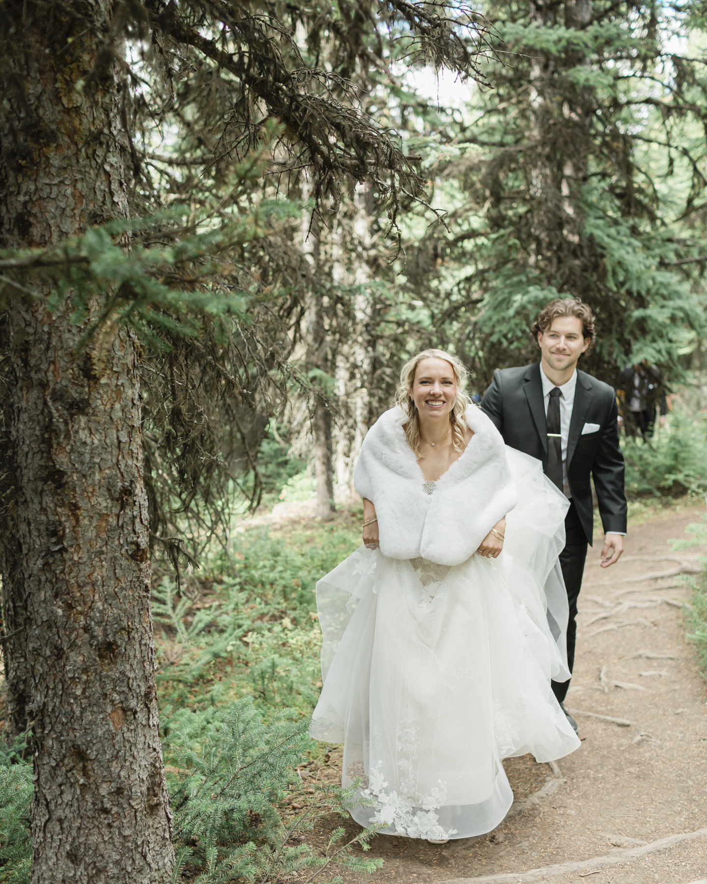 A couple walking through the forest in Banff after their elopement 