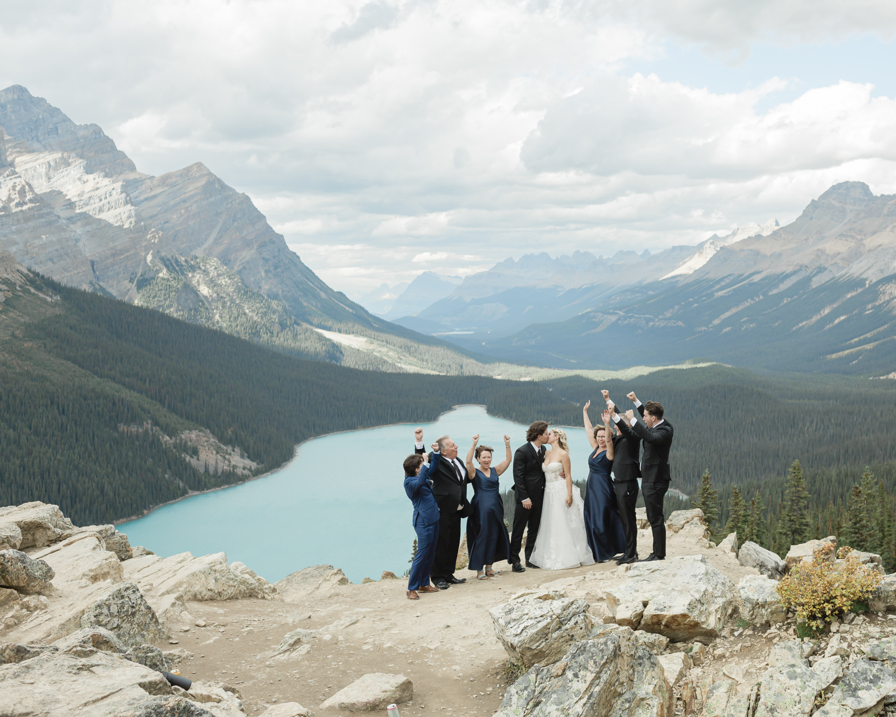 A couple kissing with their family around them in front of Peyto Lake