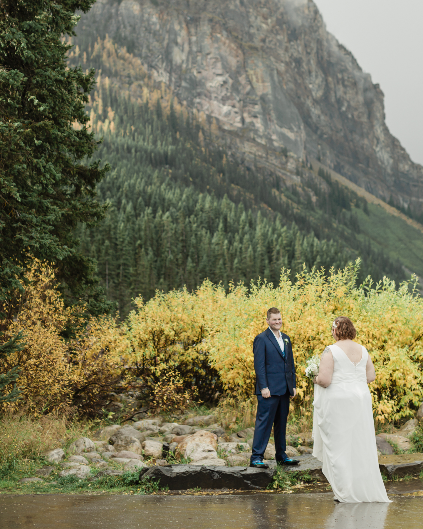 A LGBTQIA+ couple laughing together at Lake Louise in Banff 