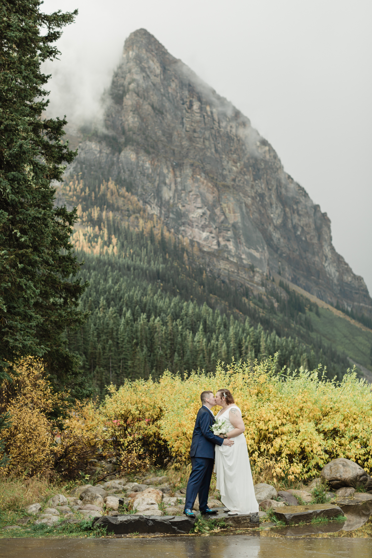 A LGBTQIA+ couple laughing together at Lake Louise in Banff 