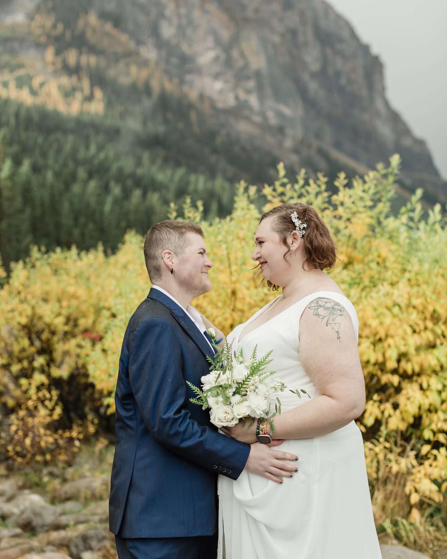 A LGBTQIA+ couple laughing together at Lake Louise in Banff 